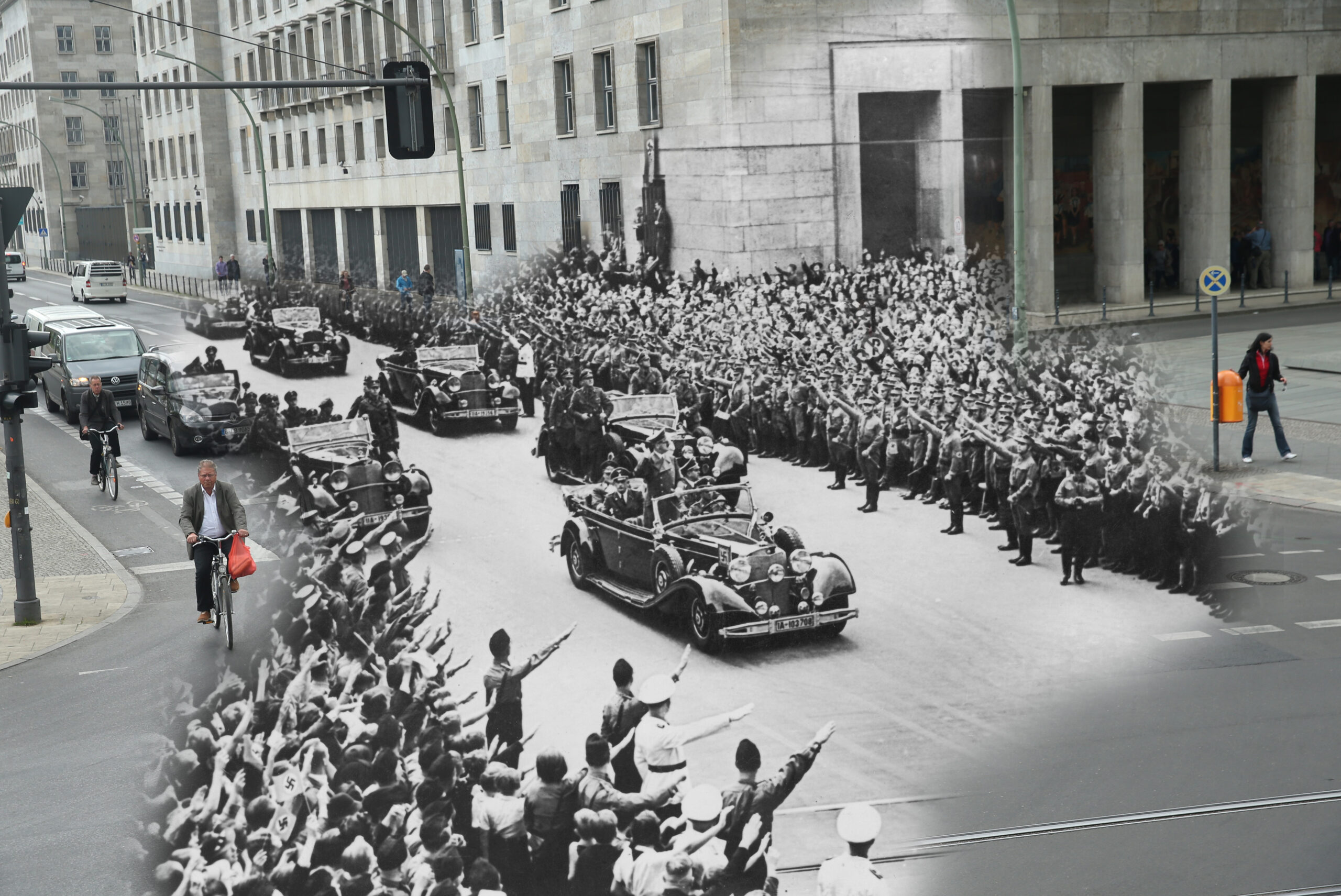 COMPOSITE: In this digital composite image a comparison has been made showing crowds saluting to Adolf Hitler passing by in a motorcade on October 2, 1938 (Photo by Keystone/Hulton Archive/Getty Images) and a view from approximately the same perspective along on April 30, 2015 in Berlin, Germany. (Photo by Sean Gallup/Getty Images) *** ARCHIVE BLACK AND WHITE *** BERLIN, GERMANY - OCTOBER 2, 1938: Crowds salute German Nazi leader Adolf Hitler (1889 - 1945) on his arrival in Berlin from Munich, 2nd October 1938. (Photo by Keystone/Hulton Archive/Getty Images) *** MODERN DAY COLOR *** BERLIN, GERMANY - APRIL 30, 2015: Cars and cyclists pass through the intersection of Wilhelmstrasse and Leipziger Strasse on April 30, 2015 in Berlin, Germany. Europe, Russia and the former Allied powers will commemorate the 70th anniversary of the end of World War II and the victory over Nazi Germany on May 8-9. (Photo by Sean Gallup/Getty Images)