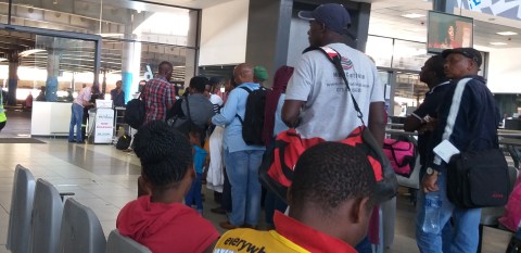Zimbabweans describe their hardship while waiting for a bus home after buying goods in SA