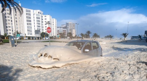 Huge waves up to 11 metres battered Cape Town coastline . At Three Anchor Bay  and all along the Atlantic seaboard , huge foamy waves crashed  over the barriers and onto the road covering cars as they drove past . Some motorists  even drove their vehicles through the foam (Photo:Brenton Geach)